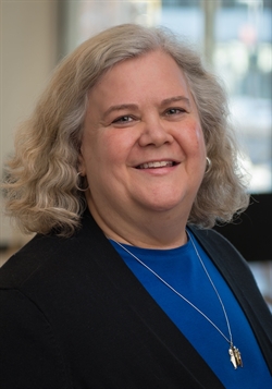 three-quarter portrait of Robin in blue shirt and black sweater